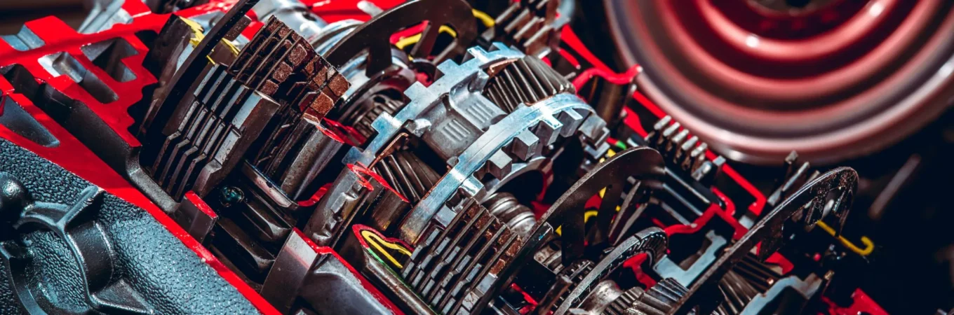 Cutaway view of a car transmission system showing internal gears, clutch plates, and shafts