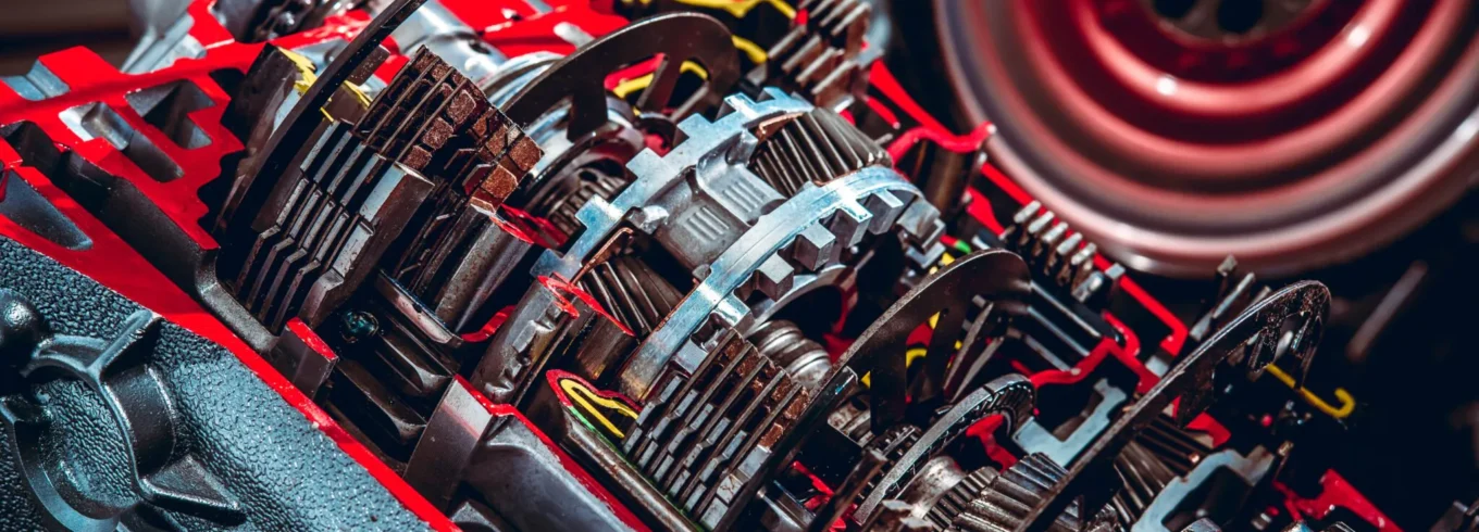 Cutaway view of a car transmission system showing internal gears, clutch plates, and shafts