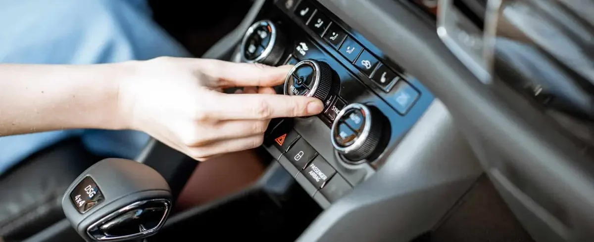 Driver adjusting car air conditioning temperature control in Singapore